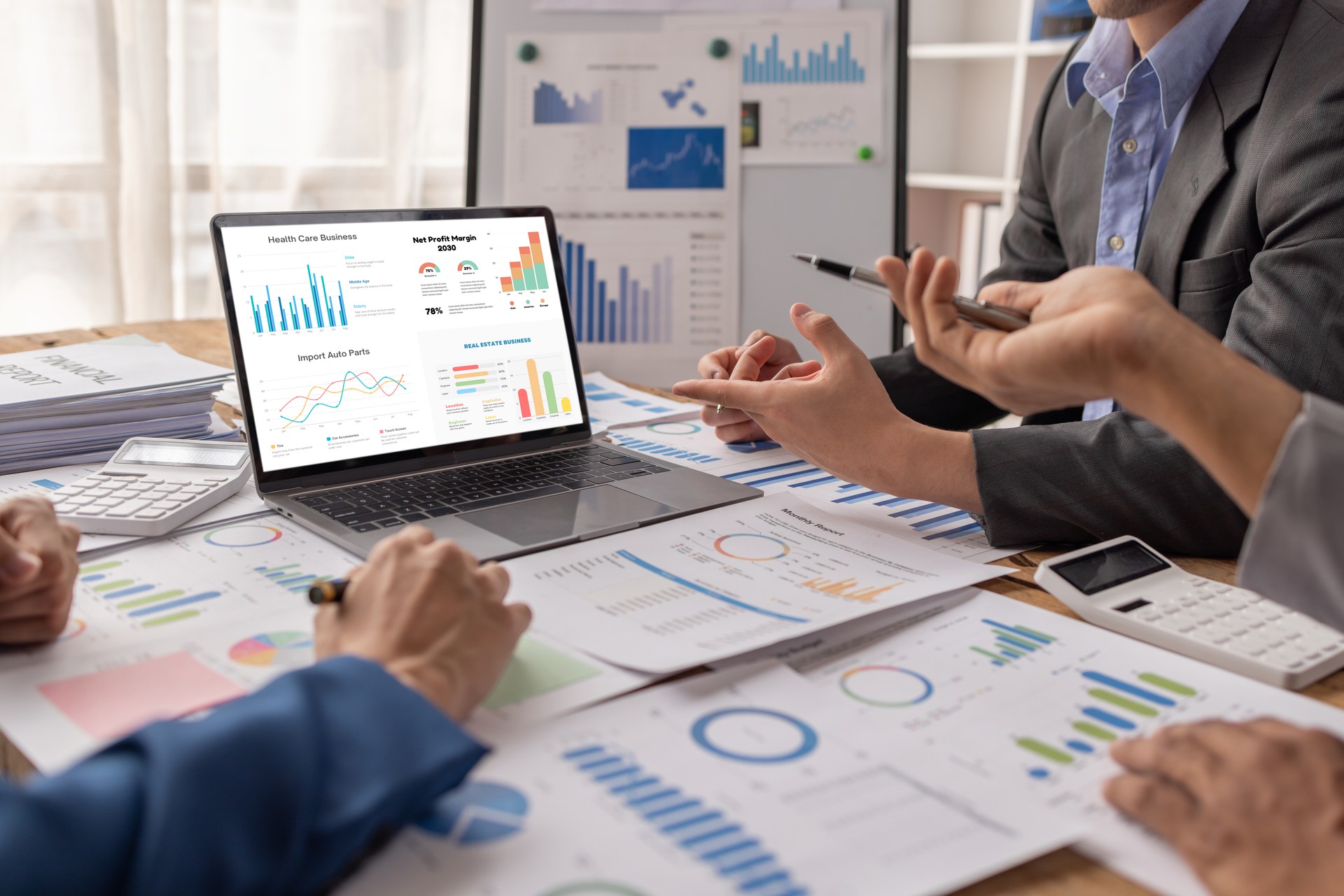 Group of confident business people point to graphs and charts to analyze market data, balance sheet, account, net profit to plan new sales strategies to increase production capacity.